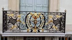 an ornate balcony railing with gold decorations on it