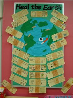 a bulletin board with sticky notes attached to it that says heal the earth and an image of a globe