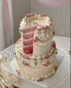 a three tiered cake with pink flowers on the top and bottom is sitting on a plate