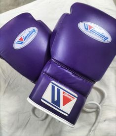 two purple boxing gloves sitting on top of a white sheet with the word virginia in it