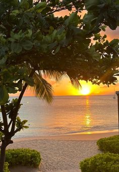 the sun is setting over the ocean and beach