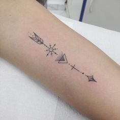 a woman's arm with an arrow and stars tattoo on the left side of her arm