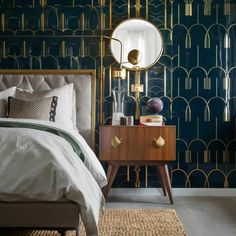 a bedroom with blue wallpaper and gold accents