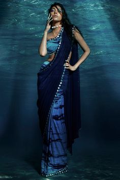 Featuring a blue pre-stitched saree in silk lycra and georgette base with tie and dye. It is paired with a matching one shoulder blouse.  FIT: Fitted at bust and waist. COMPOSITION: Silk lycra, Georgette. CARE: Dry clean only. Tie Dye Saree, Shibori Clothing, Floral Sarees, Saree Gown, Drape Saree, Purple Tie Dye, Indian Fashion Designers