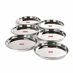 six stainless steel serving trays on white background