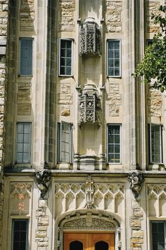 an old building with two large doors and ornate carvings on the front, along with windows