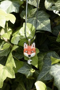 a necklace with a red fox on it