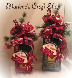 two wooden snowmen with red and black plaid bows