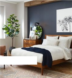 a bed room with a neatly made bed next to a chair and a table in front of a window