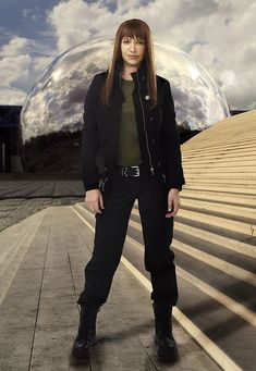 a woman standing in front of a giant mirror ball with her hands on her hips