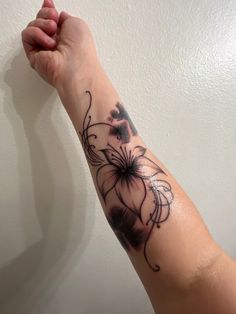 a woman's arm with a flower tattoo on it