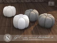 three white knitted poufles sitting on top of a wooden floor next to each other