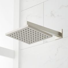 an overhead shower head in a white bathroom