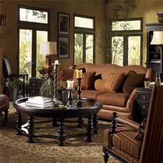 a living room with couches, chairs and a coffee table in front of a fire place