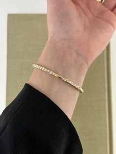 Customize your bracelet stack with this classic flexible bangle featuring round diamonds in a squared bezel setting. Available in 14k yellow gold, rose gold, and white gold Diamond Color: F/G / Diamond Clarity: VS1 Total Carat Weight: 1.60 cts Closure: Snap-Lock Clasp 4mm x 2mm / 7 inch length Made to order. Lead time is 4-6 weeks. Benefits of Solid 14k Gold Jewelry Most loved for its durability and longevity Can be worn daily and requires less maintenance and care than plated, vermeil, or silver jewelry Sweat/water resistant so you can take your beloved pieces with you no matter the occasion Will not tarnish and become brown or black overtime, but rather maintain its color Less resistant to scratches making it ideal for everyday wear Will not leave coloring on your skin when worn for long Daily Wear Diamond Bangles, Snap Lock, Diamond Color, Bracelet Stack, Diamond Clarity, Lead Time, Bezel Setting, White Gold Diamonds, Gold Rose