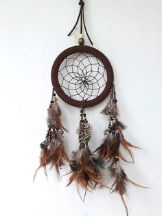 a brown and white dream catcher hanging on the wall