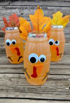 three plastic cups with fake leaves in the shape of turkeys and faces on them