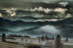 the mountains are covered in fog and clouds