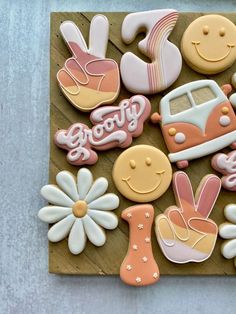 decorated cookies are arranged in the shape of cars, flowers, and other things on a wooden board