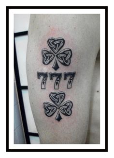 four leaf clover tattoo on the left thigh, with three different symbols in black and white