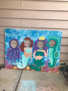 a painting on the side of a house with two mermaids and an octopus in it