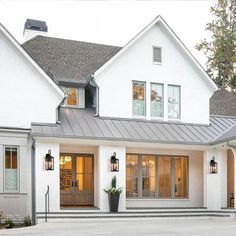 a large white house with lots of windows and lights on the front door is shown