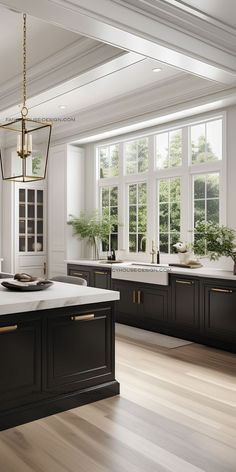 a large kitchen with an island in front of two windows and a chandelier hanging from the ceiling