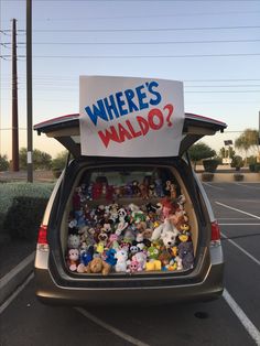 a car with stuffed animals in the back and a sign that says where's waldo?