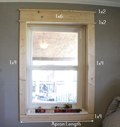 a window with measurements for the height of it in front of a bed and pillow