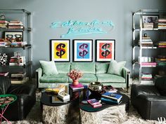 a living room filled with furniture and bookshelves next to a wall covered in pictures