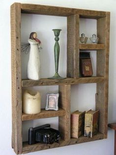 three wooden shelves with books, vases and other items on top of each shelf