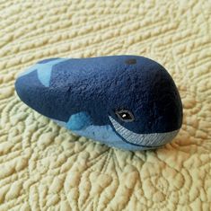 a rock shaped like a whale laying on top of a bed