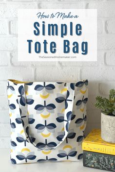 a tote bag sitting on top of a table next to books and a potted plant