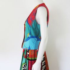 Vintage silk waistcoat by Laurèl Designer: Laurèl Size: M Materials: 100% silk Lining: 100% acetaat Colours: Red, blue, green, grey and yellow Condition: Worn, but very good Length (measured on back): 52 cm. Armpit to armpit: 45 cm. Details: The waistcoat has a lining and closes on front with buttons. Ones the lining was a little loose on the inside of the waistcoat. This is repaired. There are a few little stains on the waistcoat, but you would have to look for them. Overall in a very nice vint Retro Multicolor Sleeveless Vest, Fitted Silk Summer Vest, Vintage Multicolor Summer Vest, Fitted Multicolor Cotton Vest, Vintage Fitted Multicolor Vest, Fitted Vintage Multicolor Vest, Fitted Multicolor Vintage Vest, Silk Shirt Blouses, Versace Print