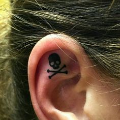 a person with a skull and crossbone tattoo on their ear