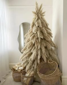 a white christmas tree sitting next to baskets in front of a mirror on the wall