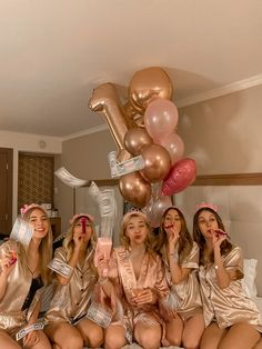 the girls are all dressed up and having fun in the bed with balloons on their heads