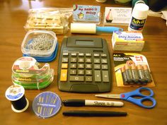 a calculator, scissors, tape measure and other items on a table