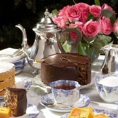 a table topped with cakes and tea cups