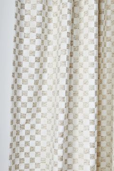 a close up view of a white and beige checkered curtain