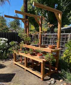 a wooden bench with potted plants on it