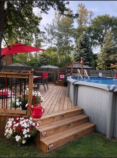 an above ground swimming pool with steps leading up to the deck and umbrellas over it