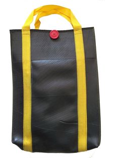 a black and yellow tote bag with a red button on the front, sitting against a white background