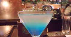 a blue drink sitting on top of a bar