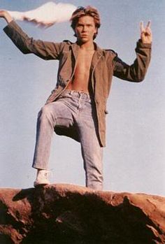 a man standing on top of a rock with his hands in the air