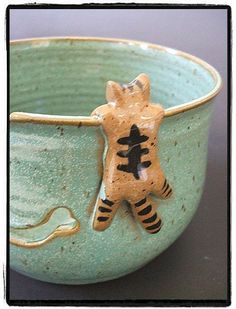 a ceramic bowl with a tiger design on the side and a cat decoration on the inside