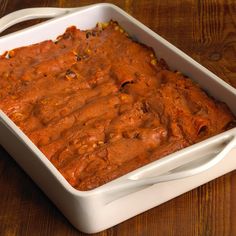 a casserole dish filled with food on top of a wooden table