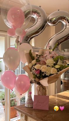 a bouquet of flowers and balloons are on the counter