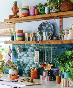 a kitchen counter topped with lots of pots and pans on top of wooden shelves