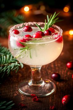 a cocktail with cranberries and rosemary garnish